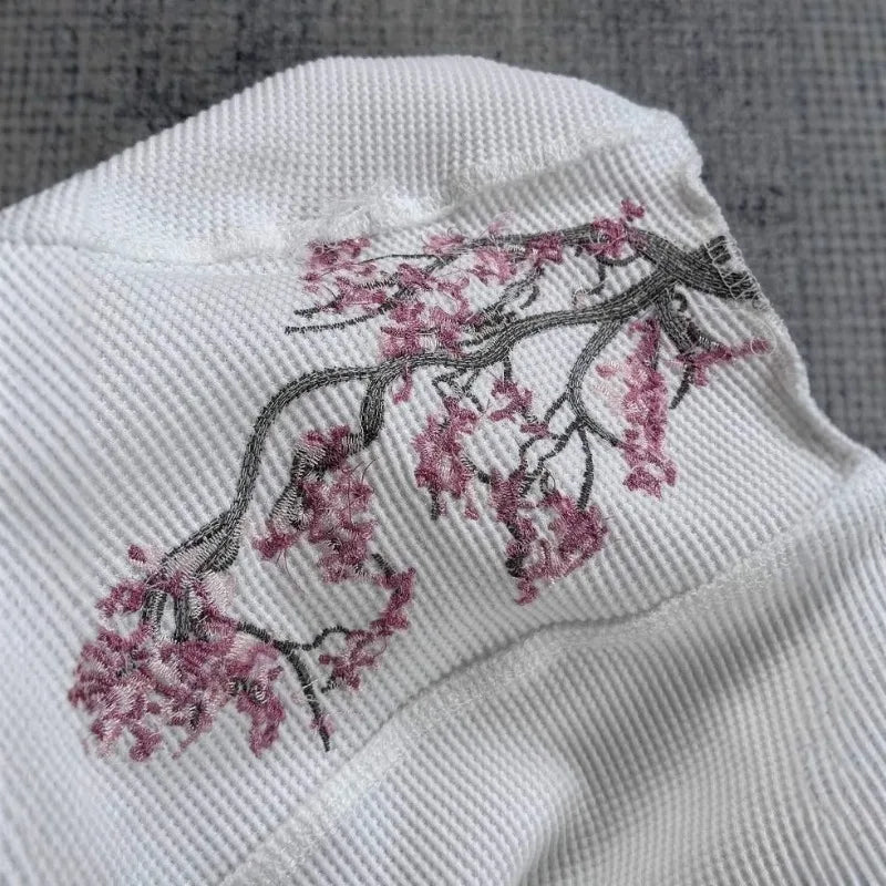 White Cherry Blossom T-shirt from Deeptown, featuring a soft fabric and floral print, worn by a model showcasing casual style.