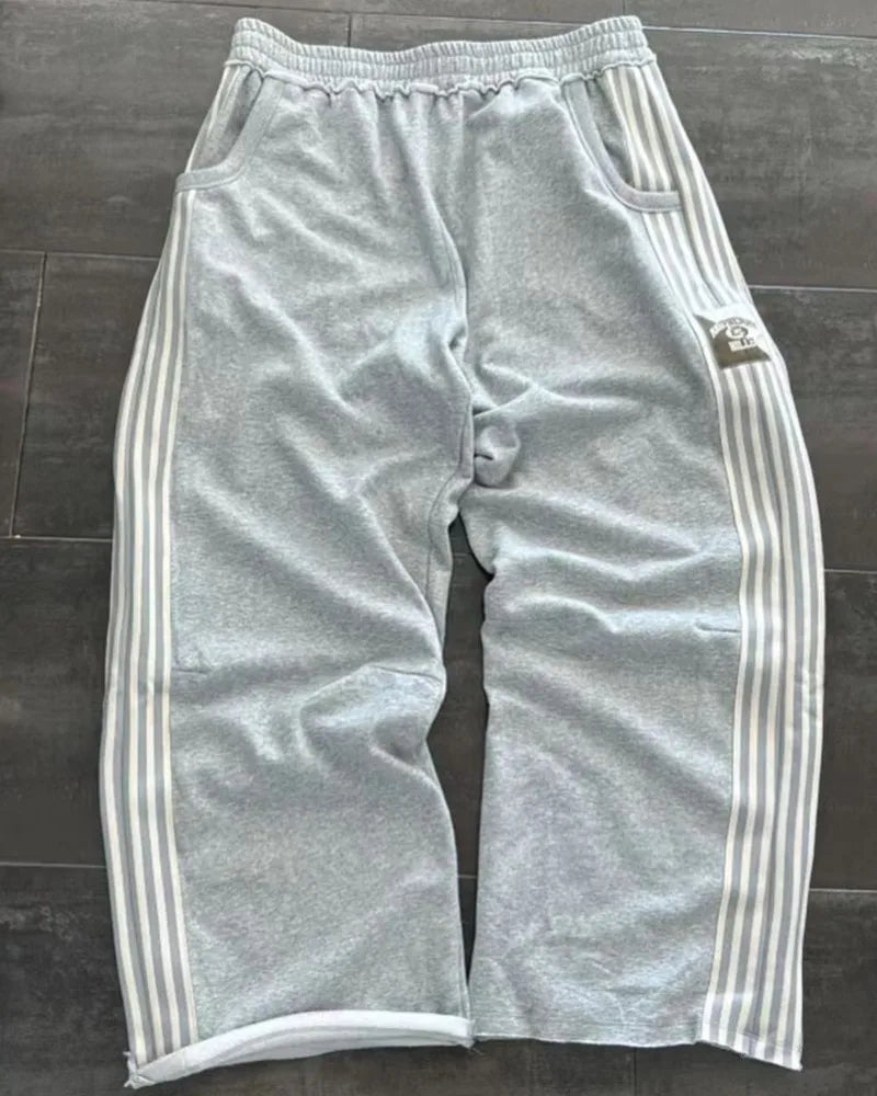 NOIZSY striped baggy pants with wide legs and relaxed fit, featuring horizontal black and white stripes, front pockets, and drawstring waist