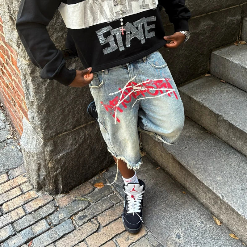 Y2K graffiti-style denim jorts with colorful street art design, casual cut, and distressed details, perfect for trendy summer outfits.